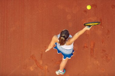 Maç sırasında sahada bir kadın tenisçi havadan çekilmiş. Tenis oynayan genç bir kadın. Yüksek açı görünümü.
