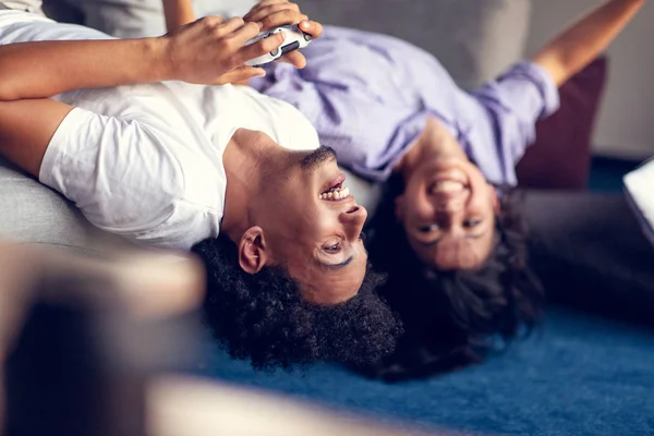 Joven pareja sonriente jugando videojuegos en casa . — Foto de Stock