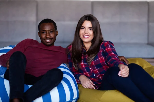 Pareja feliz con la tableta de ordenador y teléfono inteligente en un sofá — Foto de Stock