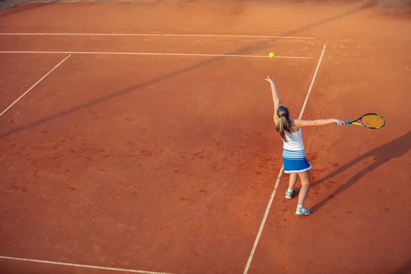 Sportif kıyafeti ve sağlıklı bir yaşam tarzı ile toprak kortta Tenis oynayan kadın — Stok fotoğraf