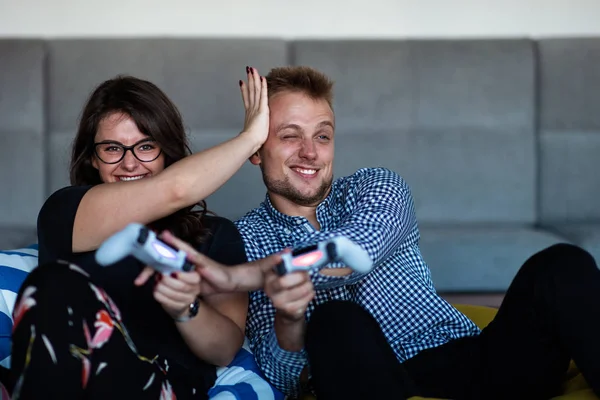 Joven pareja sonriente jugando videojuegos en casa . — Foto de Stock