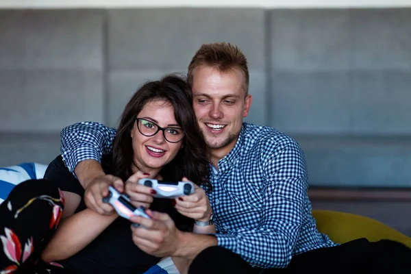 Joven pareja sonriente jugando videojuegos en casa . — Foto de Stock