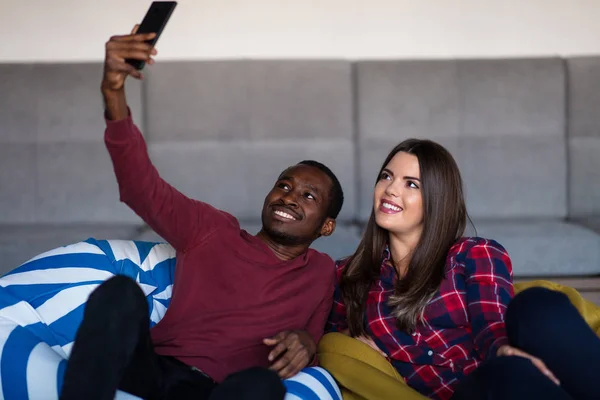 Šťastný pár s počítačovým tabletem a smartphone na pohovce — Stock fotografie