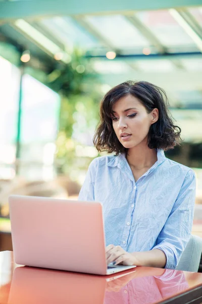 Fiatal és gyönyörű lány notebook és laptop ül egy kávézóban — Stock Fotó