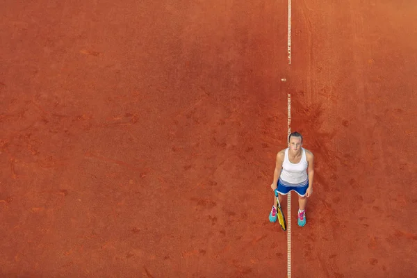 Tiro aéreo de uma tenista feminina em uma quadra durante o jogo. Jovem mulher jogando tennis.High ângulo vista . — Fotografia de Stock