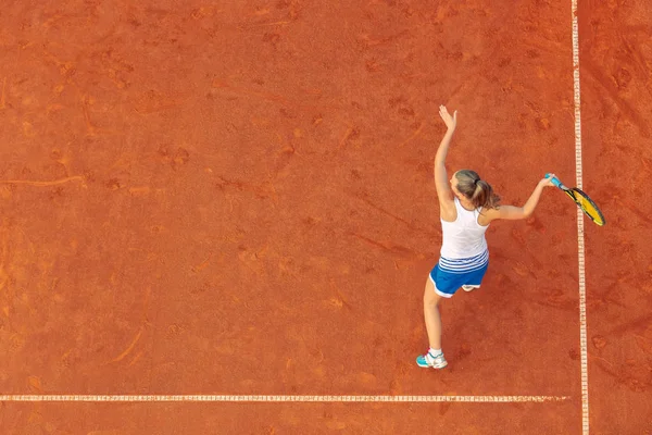 比赛时在球场上对一名女网球运动员的空中射击。打网球的年轻女子。高角度视图. — 图库照片