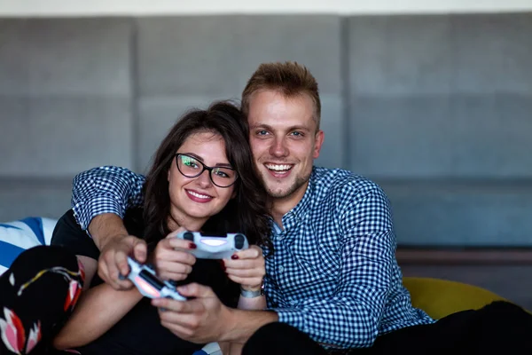 Joven pareja sonriente jugando videojuegos en casa . — Foto de Stock