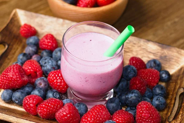 Milk shake orman meyve (ahududu, çilek ve yaban mersini) cam cup bardağı taşıran damla ile birlikte içmek için hazırlanan