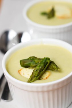 Sağlıklı yaz yemek. Kuşkonmaz çorbası krem dokulu beyaz bardak ekmek chip ve yeşil kuşkonmaz ile servis