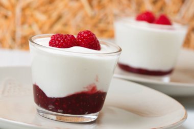 Taze ahududu ve ahududu reçelli bir bardak taze yoğurt.