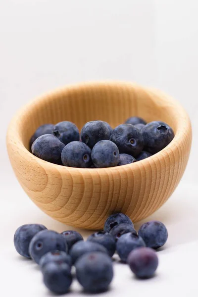 Handful Fresh Blueberries Partially Spilled Out Wooden Bowl Vertical Isolated — Stock Photo, Image