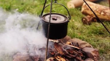 Demir kazanda dışarıda yemek pişirmek.