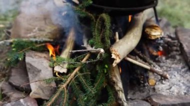 Demir kazanda dışarıda yemek pişirmek.