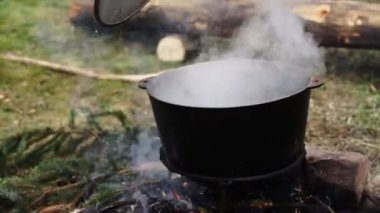 Demir kazanda dışarıda yemek pişirmek.