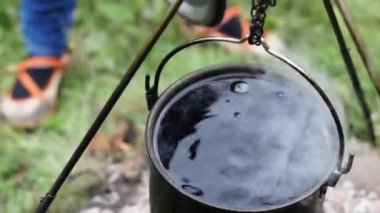 Demir kazanda dışarıda yemek pişirmek.