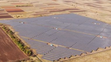 Güneş Panelleri Çiftliği 'nin (güneş pili) güneş ışığıyla 4k hava görüntüsü. İnsansız hava aracı Ukrayna 'da güneş panelleri üzerinde uçuyor yenilenebilir yeşil enerji konsepti.