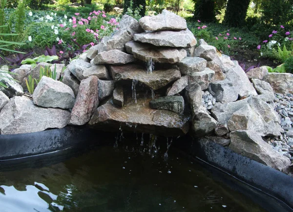Pequena lagoa de água de pedras no jardim botânico. Cachoeira — Fotografia de Stock