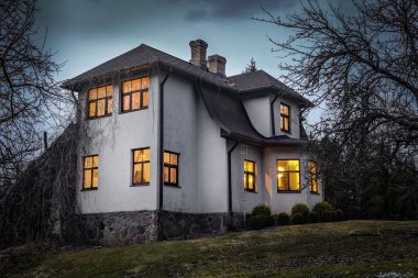 Romantik ev penceresinde bir ışıkla. Yaz aylarında gece manzarası