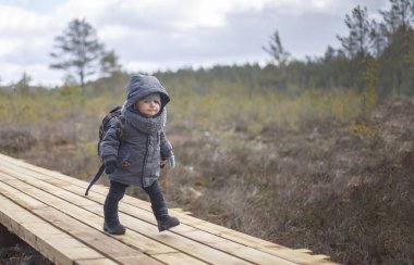 Küçük çocuk gitmek hiking sırt çantası ile Orman soğuk bir günde