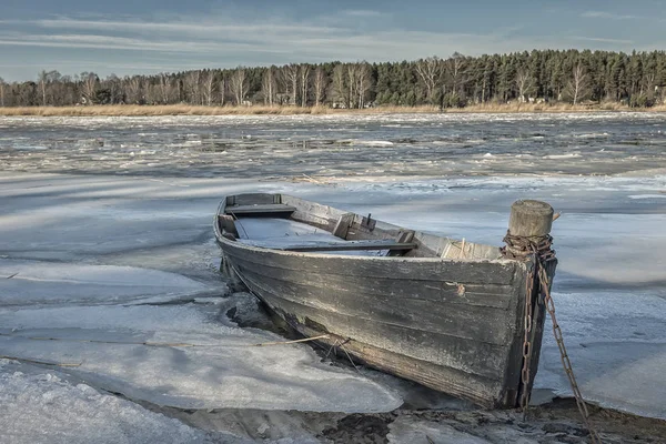 Winter scene of old wooden boat on ice of frozen lake. — Stock Photo, Image