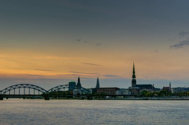 Riga 'daki nehir kıyısında gece görüşü yansıyor.,