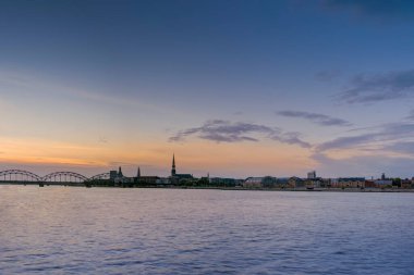 Riga 'daki nehir kıyısında gece görüşü yansıyor.,