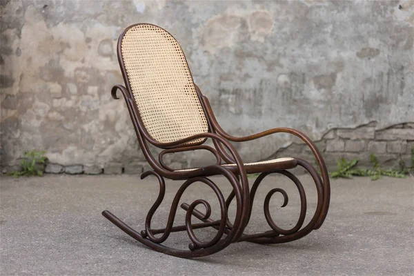 Old vintage dark brown rocking chair on a grey background — Stock Photo, Image