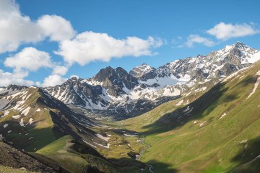 dağ doruklarına manzara resimde arka yamaçlarında kar kalıntıları ile yeşil çim ile büyümüş dağ Vadisi