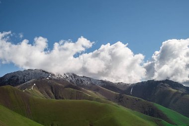 yamaçları dağ aralıkları ile kaya oluşumları ve yeşil çim manzara arka plan resmi