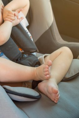 küçük bir çocuk araba, bacaklar ve topuklu yakın çekim çocuk koltuğuna oturan