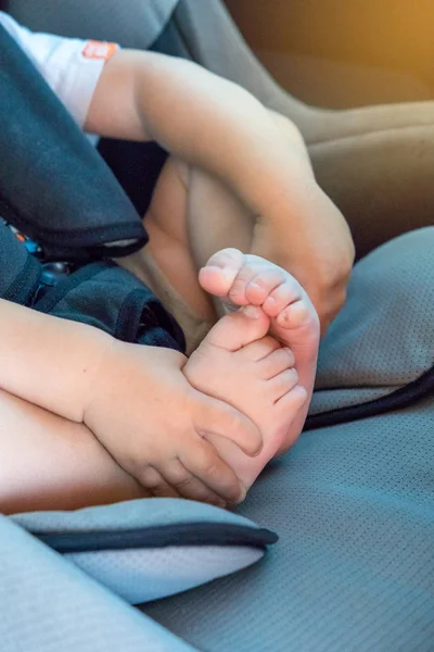 küçük bir çocuk araba, bacaklar ve topuklu yakın çekim çocuk koltuğuna oturan