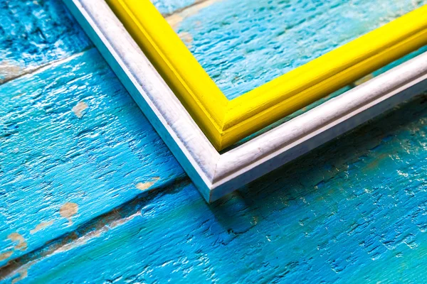 青いテクスチャ木製壁面内の空白領域で写真や画像の白枠枠内を黄色 — ストック写真