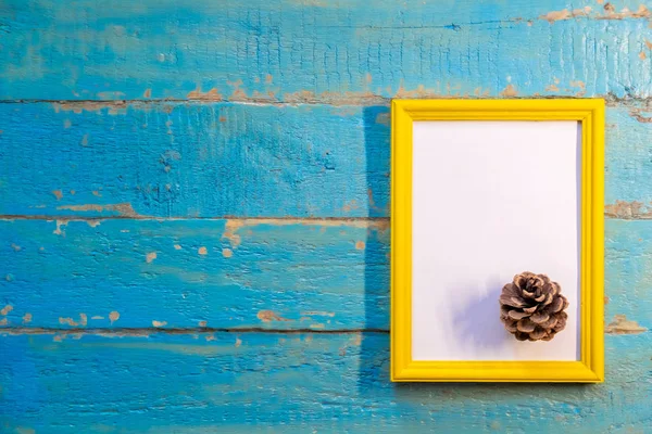 Dennenappel Ligt Een Gele Frame Met Een Witte Achtergrond Een — Stockfoto