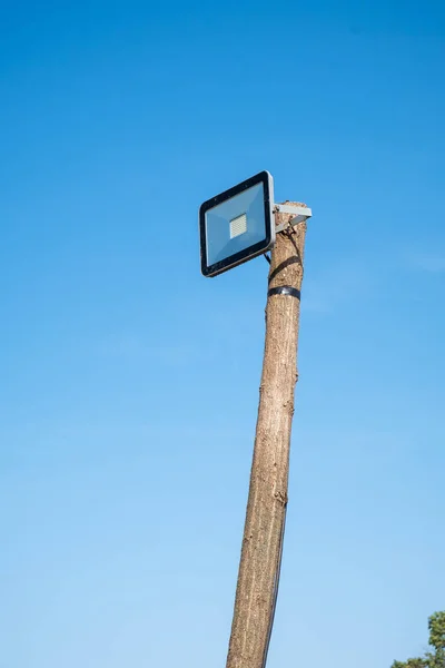 Led Sokak Lambası Mavi Gökyüzü Karşı Bir Ahşap Ağaç Gövdesi — Stok fotoğraf