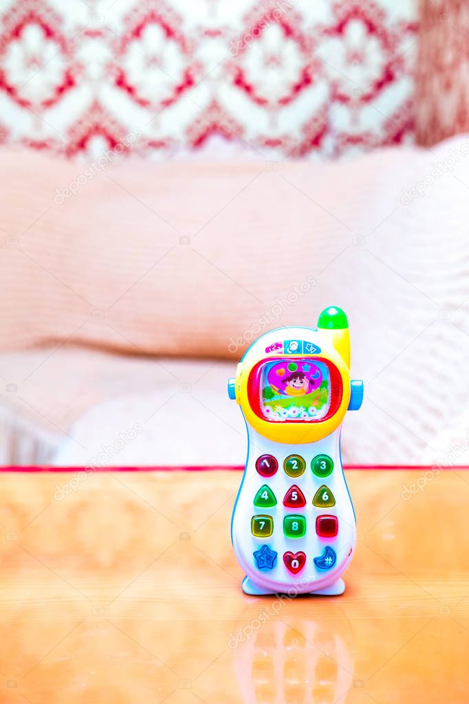 baby monitor children's toy phone with colored buttons is on the table in the room