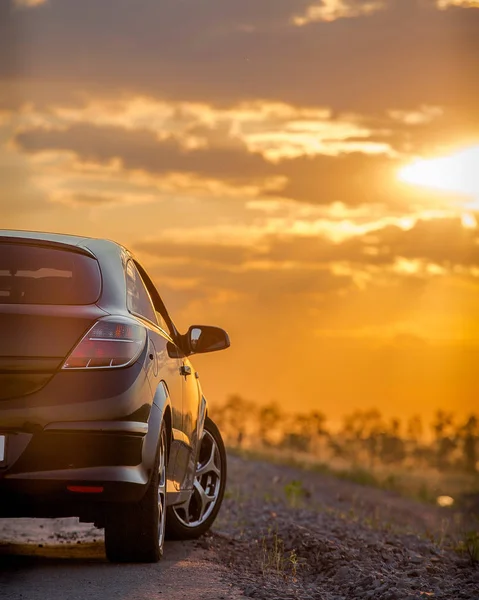 Kaunis Musta Moderni Auto Seisoo Asfalttitiellä Kesällä Auringonlaskun Säteiden Valaisemana — kuvapankkivalokuva