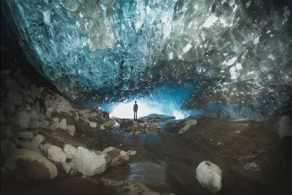silhouette of a man in a glacier cave of blue ice Dombay Karachay-Cherkessia Russia