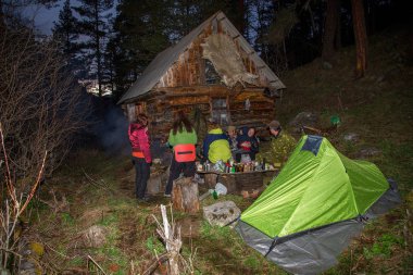 Teberda, Karaçay-Çerkes Cumhuriyeti, Rusya, 05/04/2014. Ahşap kulübe yanındaki ormanda dinlenme akşam turist bir grup