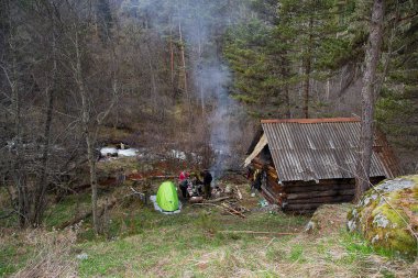 Teberda, Karaçay-Çerkes Cumhuriyeti, Rusya, 05/04/2014. Ahşap kulübe yanındaki ormanda dinlenme akşam turist bir grup
