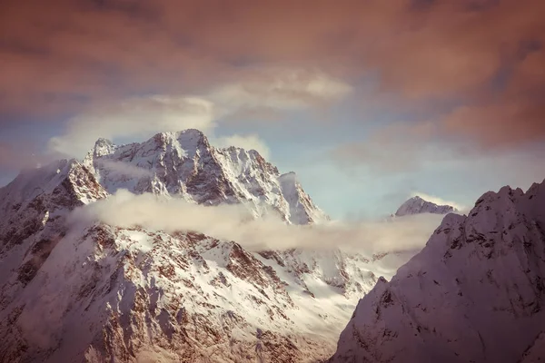Szczyty Gór Dombai Pokryte Śniegiem Otoczony Przez Gęste Chmury Tle — Zdjęcie stockowe