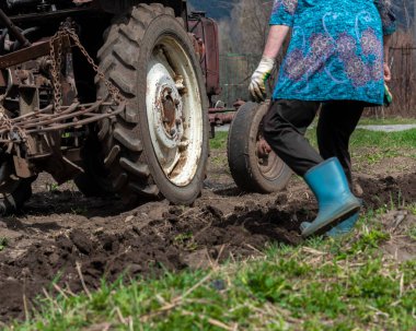 Kadın, baharda Kafkasya 'da, eski traktör harrow tarlasının yanında koşuyor.. 