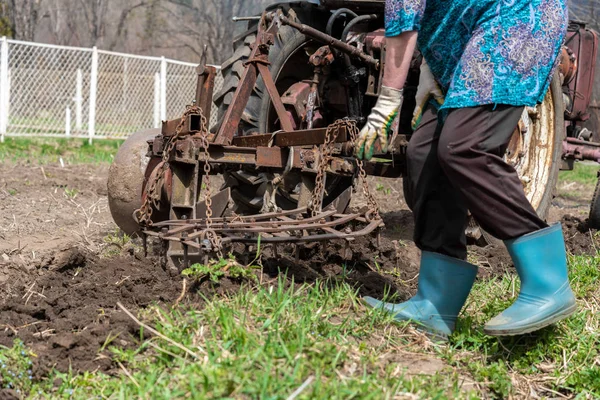 Kadın, baharda Kafkasya 'da, eski traktör harrow tarlasının yanında koşuyor.. 