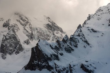 kayaların ve dağ zirvelerinin zirveleri mavi bir gökyüzüne karşı beyaz kar ile kaplıdır. Kabardey-Balkar, Rusya Federasyonu