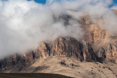 mavi bir gökyüzüne karşı kalın beyaz bulutlar kayalar ve dağ zirveleri zirveleri. Rusya Kabardey-Balkarya Cumhuriyeti'nde Bylym Gölü