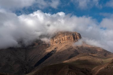 mavi bir gökyüzüne karşı kalın beyaz bulutlar kayalar ve dağ zirveleri zirveleri. Rusya Kabardey-Balkarya Cumhuriyeti'nde Bylym Gölü