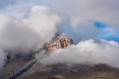 mavi bir gökyüzüne karşı kalın beyaz bulutlar kayalar ve dağ zirveleri zirveleri. Rusya Kabardey-Balkarya Cumhuriyeti'nde Bylym Gölü