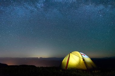 Samanyolu ile gece gökyüzüne karşı sarı renk turist çadırı