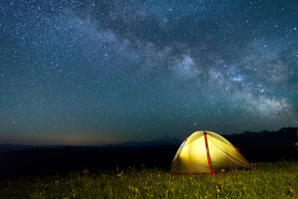Samanyolu ile gece gökyüzüne karşı sarı renk turist çadırı