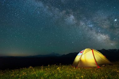 Samanyolu ile gece gökyüzüne karşı sarı renk turist çadırı