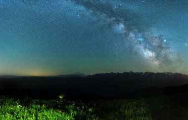 birçok yıldız ve dağların üzerinde samanyolu ile karanlık gece gökyüzü